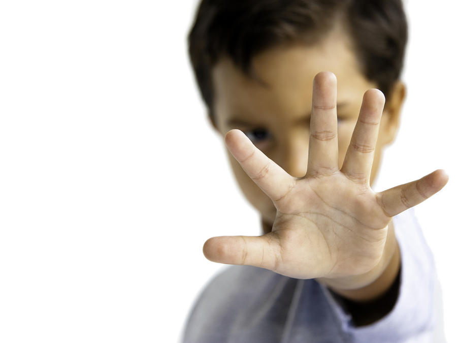 Young Boy With Hand Outstretched Makes A Stop Gesture Photograph by Lathuric