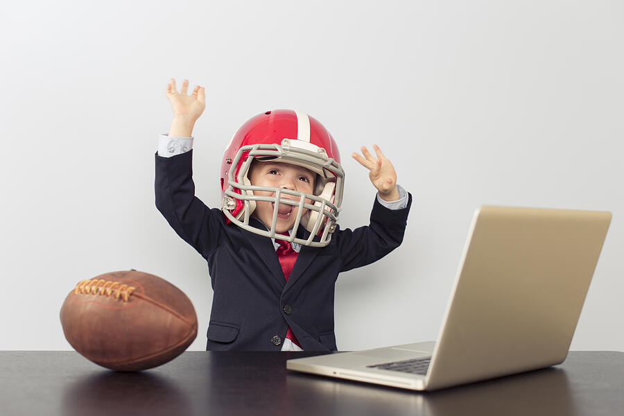 Young Business Boy in Football Helmet at Laptop Photograph by RichVintage