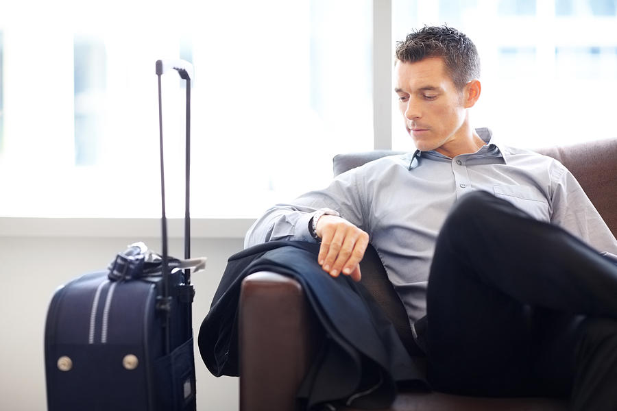 Young business man at the airport lounge checking time Photograph by Jacob Wackerhausen