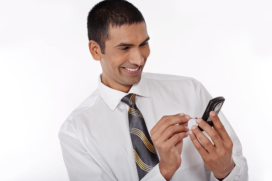 Young business man operating a mobile phone Photograph by Visage