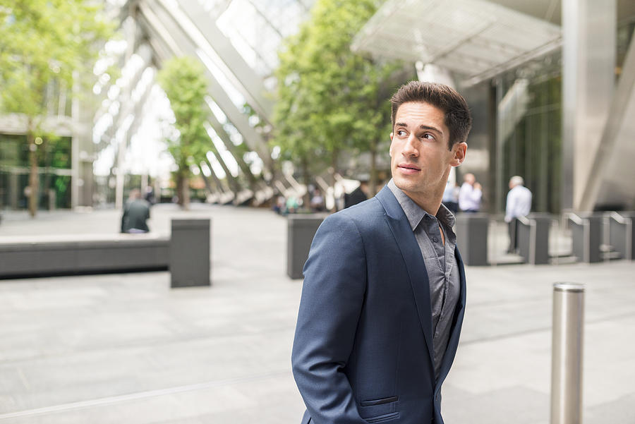 Young businessman looking over his shoulder at Broadgate Tower, London, UK Photograph by Ben Pipe Photography