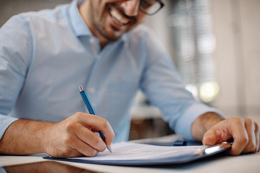 Young businessman signing a contract Photograph by Djiledesign