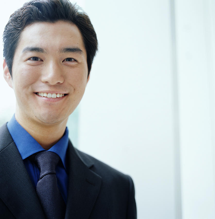 Young businessman smiling, close-up, portrait Photograph by Ryan McVay