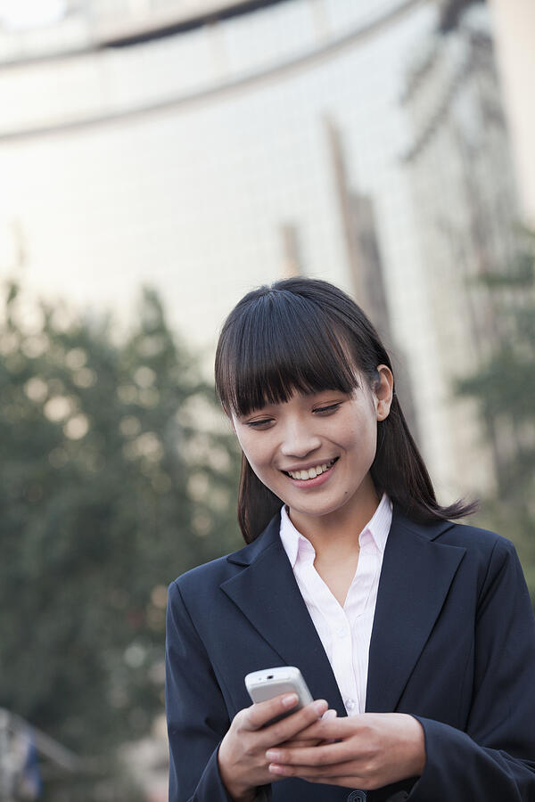 Young Businesswoman texting a message Photograph by XiXinXing