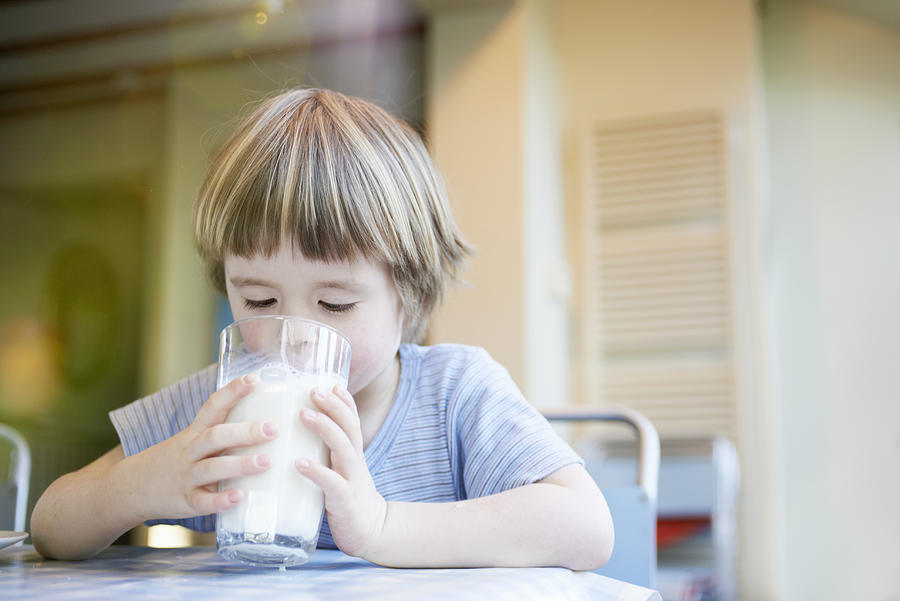 Young Child Drinking Large Glass Of Milk Photograph by Tara Moore