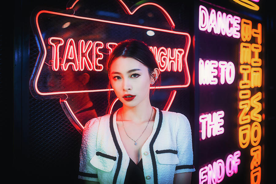Young chinese woman standing next to neon lights Photograph by Philippe Lejeanvre