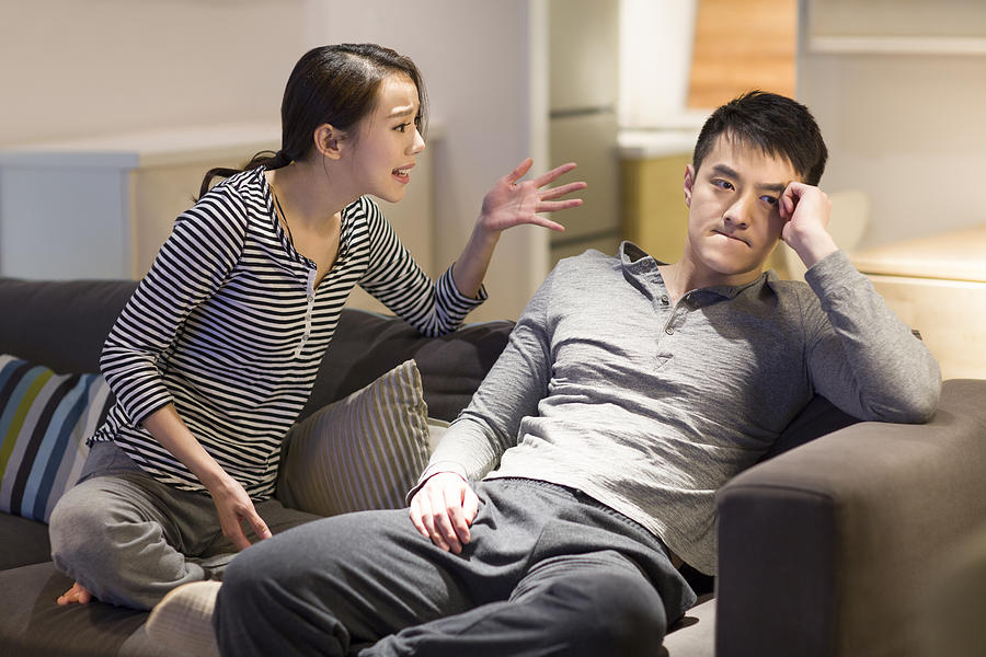 Young couple arguing on living room sofa Photograph by BJI / Blue Jean Images