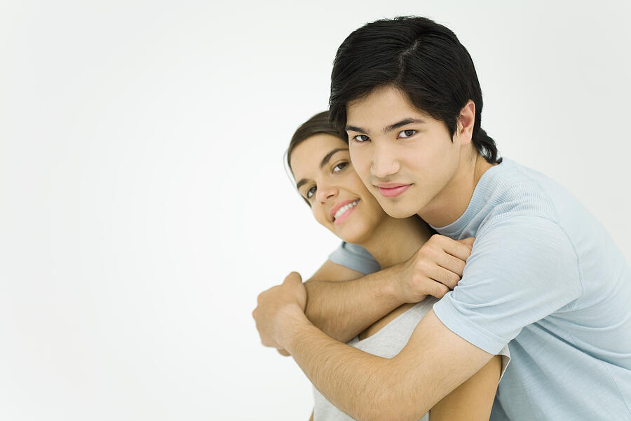 Young couple embracing, smiling at camera Photograph by PhotoAlto/Ale Ventura