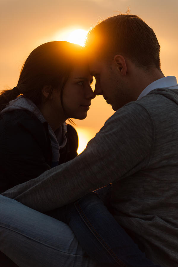 Young couple face to face in sunset. Photograph by Guido Mieth