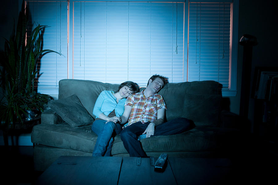 Young couple fallen asleep in front of tv Photograph by Image Source