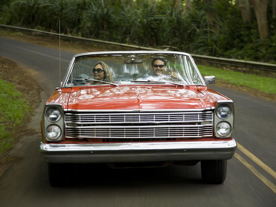 Young couple in a convertible car Photograph by Rubberball