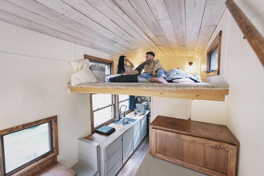 Young couple in bedroom loft of tiny house Photograph by Tony Anderson