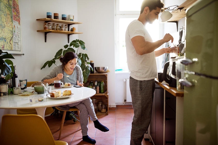 Young couple in kitchen in morning Photograph by Luis Alvarez