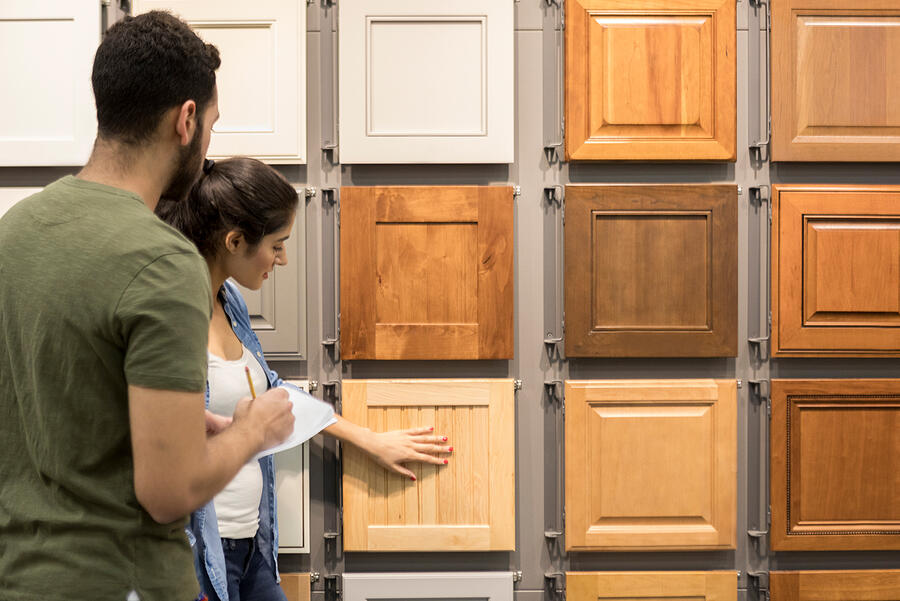 Young couple look at cabinet samples in home improvement store Photograph by SDI Productions