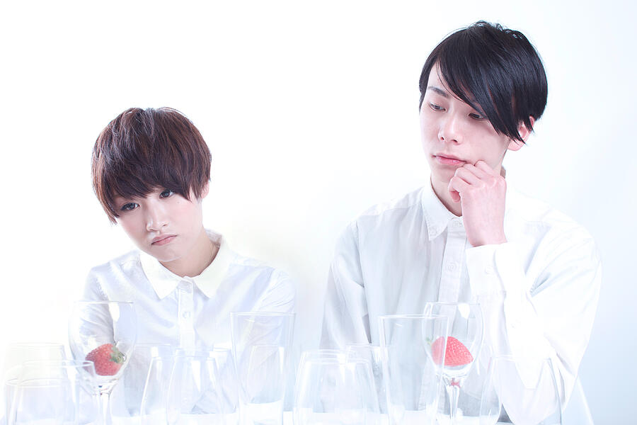 Young couple looking at strawberry in a glass Photograph by Tadamasa Taniguchi