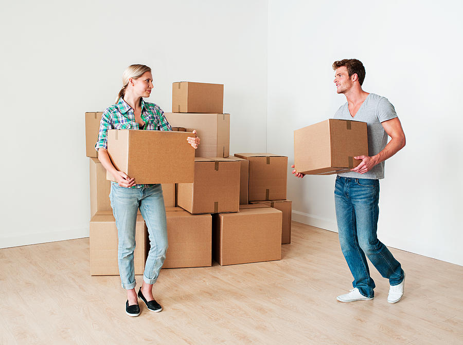 Young couple moving boxes Photograph by Image Source