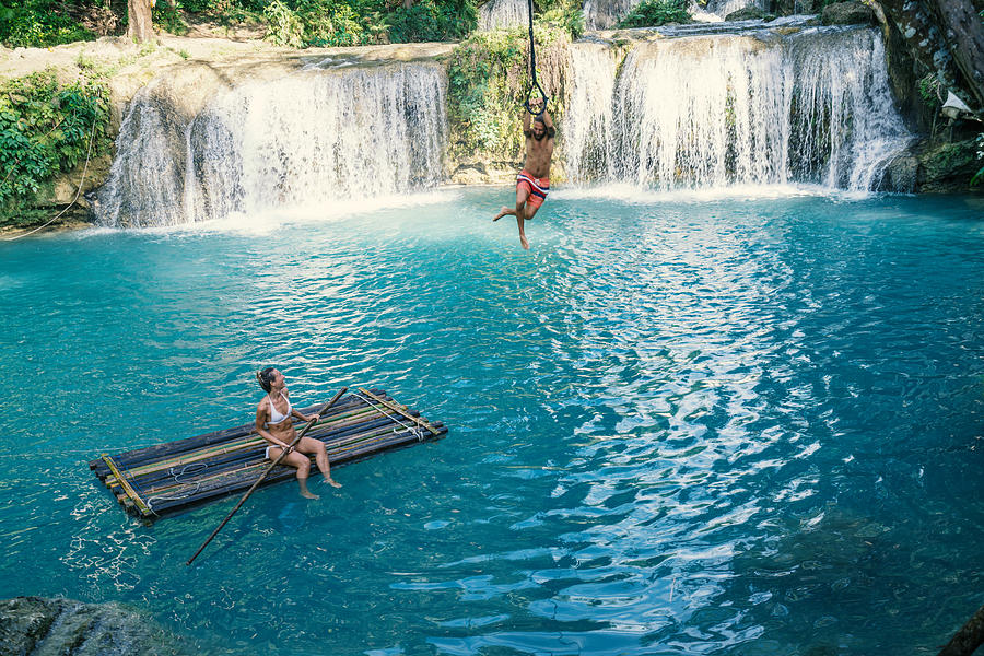 Young couple playing at beautiful waterfall in the Philippines Photograph by Swissmediavision