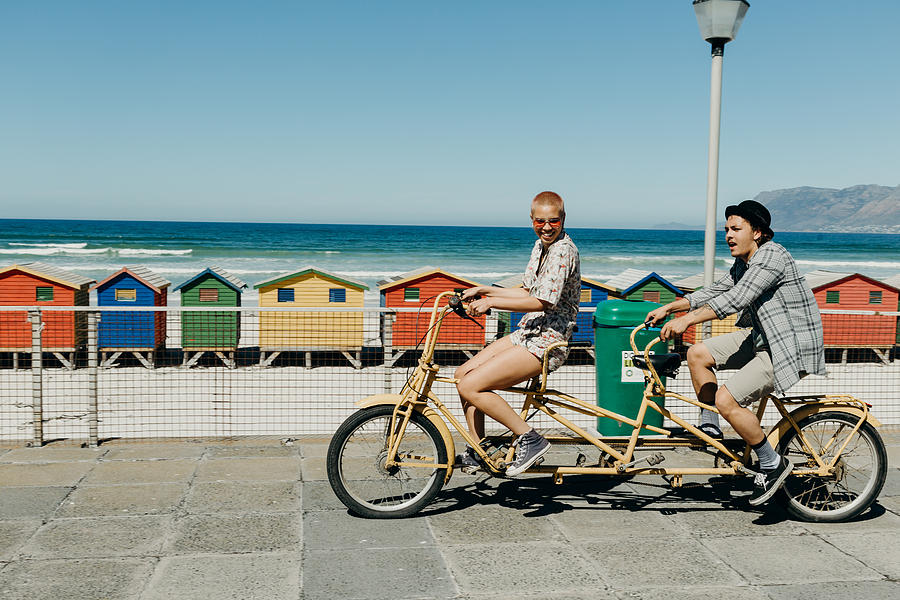 Young couple riding a tandem bicycle on a boardwalk Photograph by Hello World