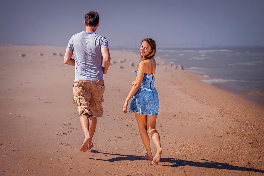 Young Couple Running On Sandy Hook Beach, New Jersey, Usa. Photograph
