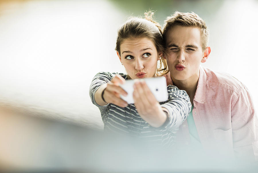 Young couple taking a selfie with smartphone Photograph by Westend61