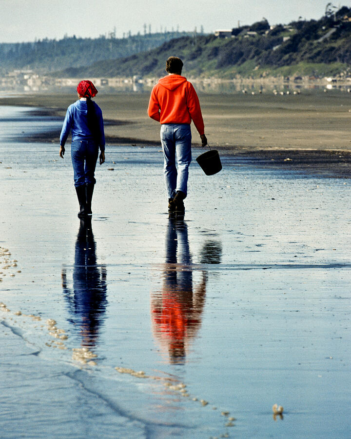 Young Couple Walking on Beach is Reflected in Wet  Sand Photograph by JeffGoulden