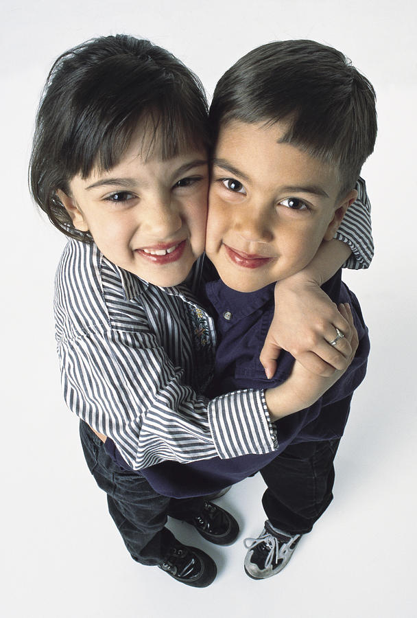 Young Cute Ethnic Siblings Hug Each Other And Smile Photograph by Photodisc