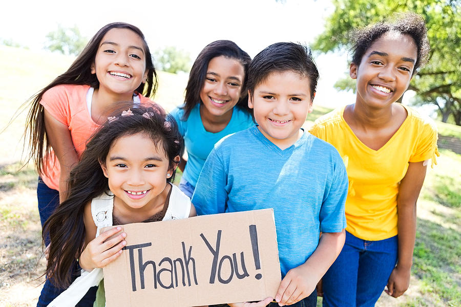 Young diverse friends in local park hold Thank You! sign Photograph by SDI Productions