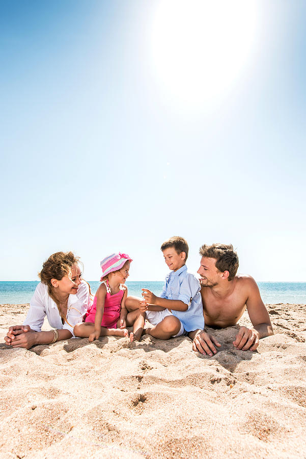 Young family enjoying at the beach. Photograph by BraunS