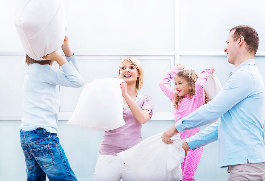 Young family having a pillow fight! Photograph by Skynesher