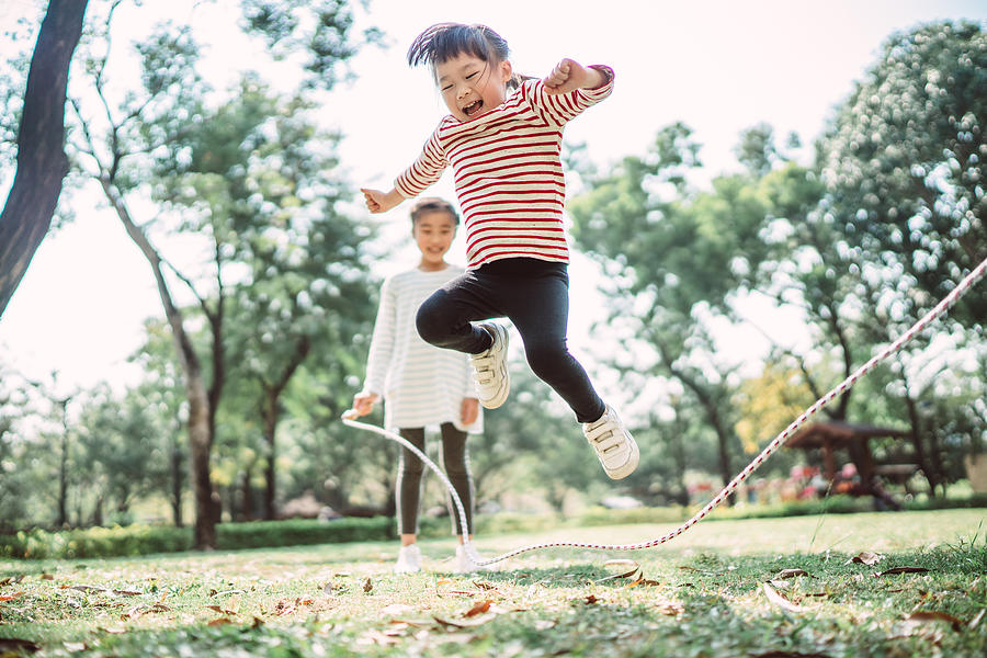 Young family jumping rope joyfully on the lawn Photograph by Images By Tang Ming Tung