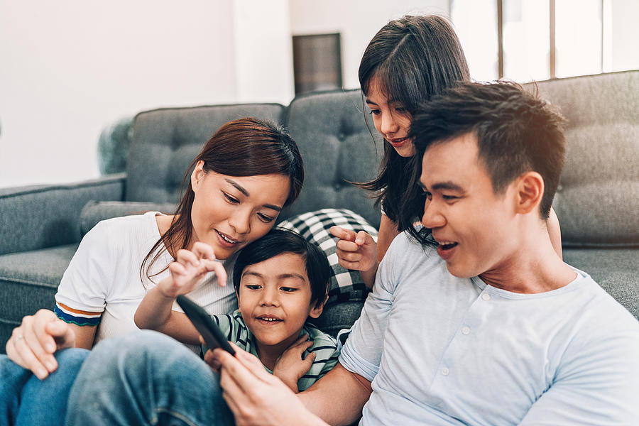 Young family texting at home Photograph by Pixelfit
