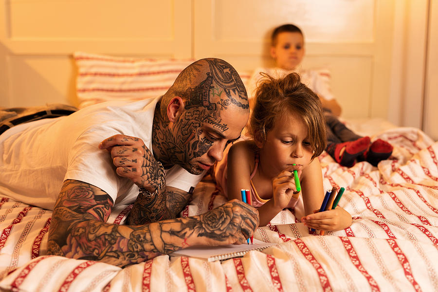 Young father and his daughter drawing in the bedroom. Photograph by Skynesher