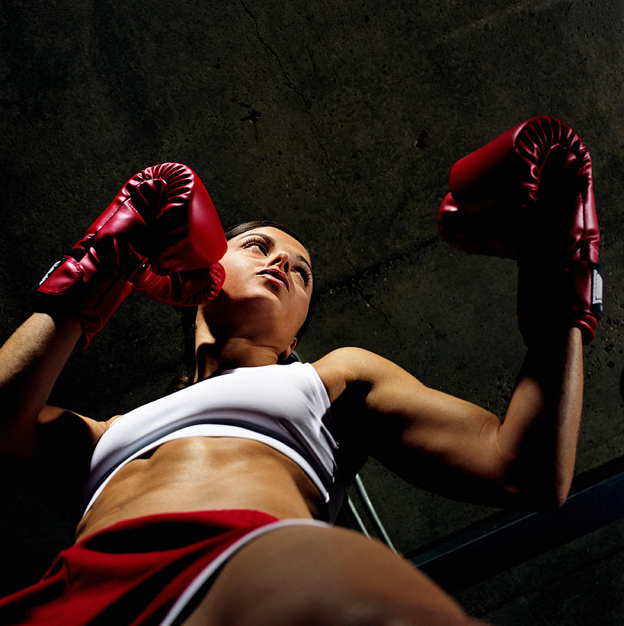 Young female boxer with gloves raised, low angle view Photograph by Digital Vision.