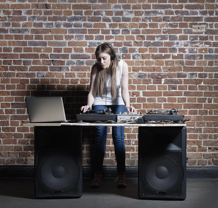 Young Female DJ Mixing on Decks and Laptop Photograph by Mike Harrington