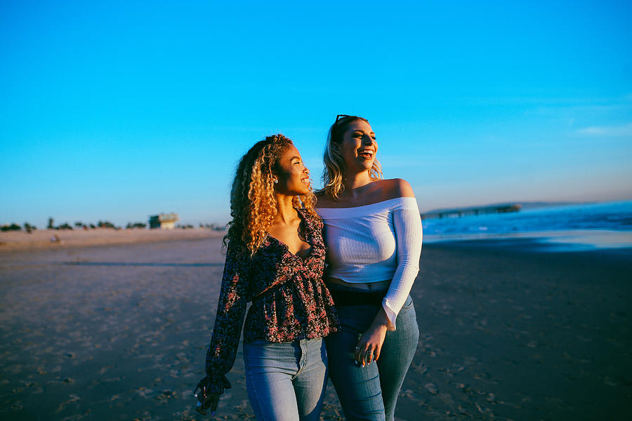 young female friends enjoying the walk on the Venice beach in LA, California Photograph by Lechatnoir