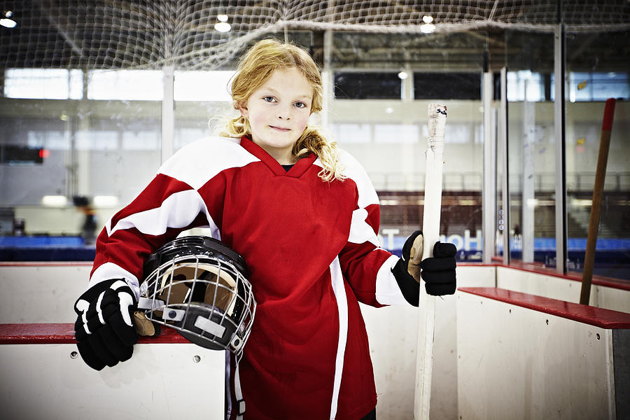 Young female ice hockey player in players box Photograph by Thomas Barwick