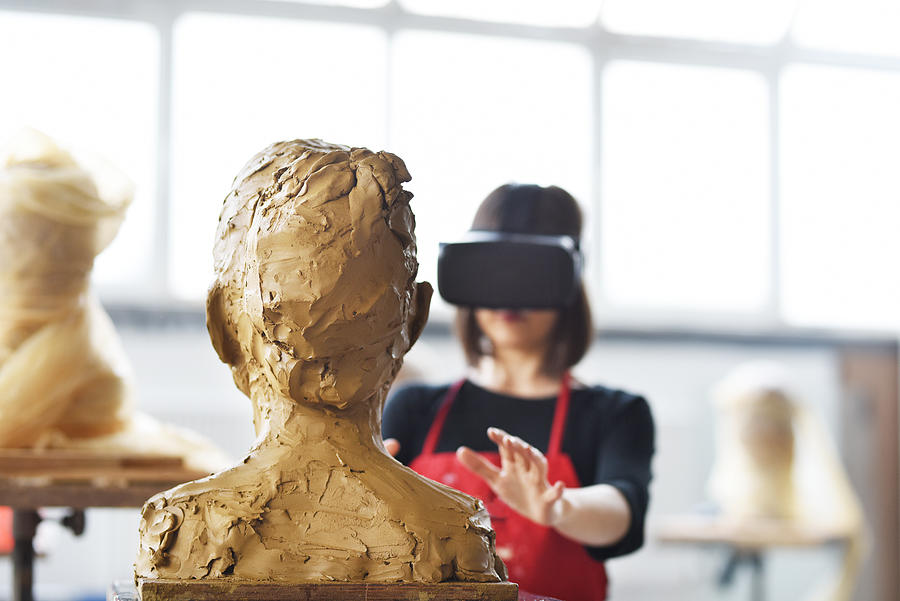 Young Female Sculptor is working with VR in her studio Photograph by Baranozdemir