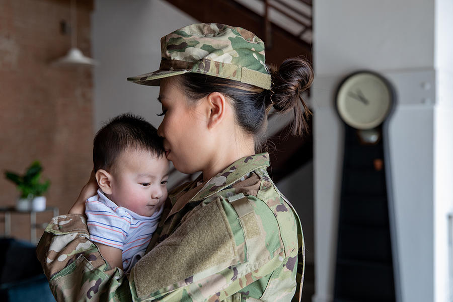 Young female soldier has bonding moment with newborn son before reporting for military duty Photograph by Courtney Hale