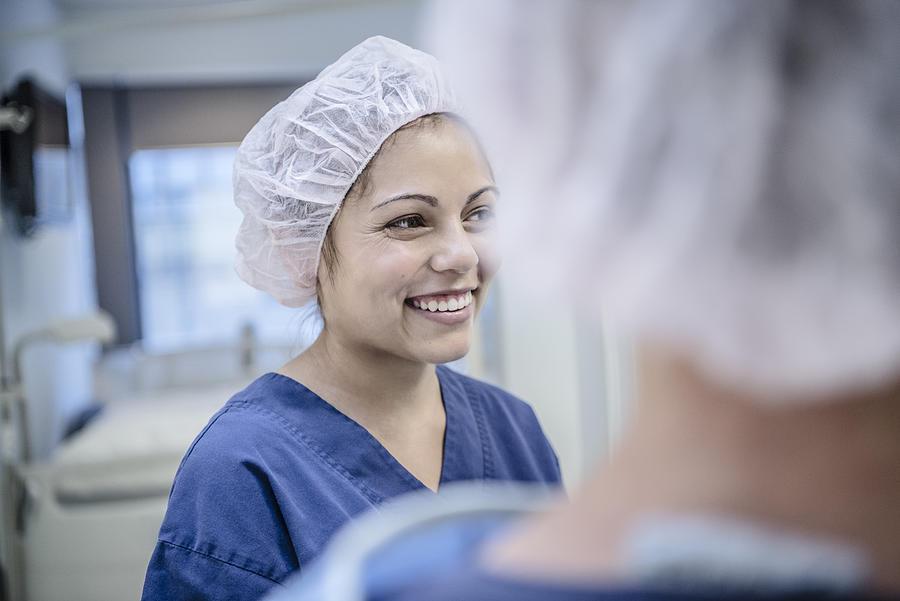 Young female surgeon in hospital smiling, candid portrait Photograph by JohnnyGreig