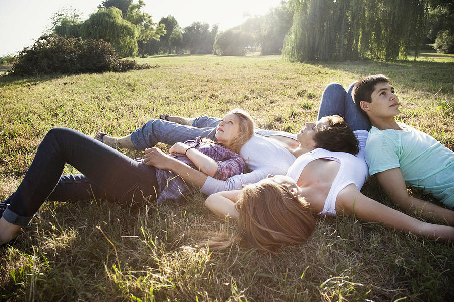 Young friends relaxing in a park Photograph by Oliver Rossi