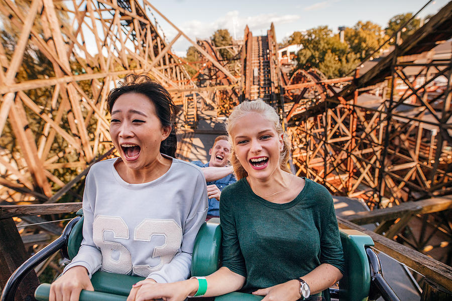 Young friends riding roller coaster ride Photograph by Jacob Ammentorp Lund