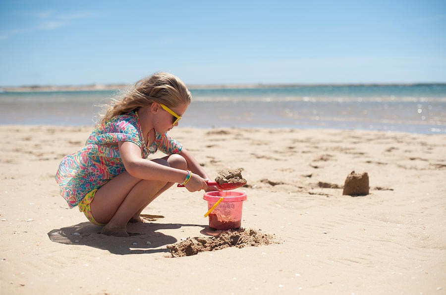 Young girl building sandcastles Photograph by Images by Christina Kilgour