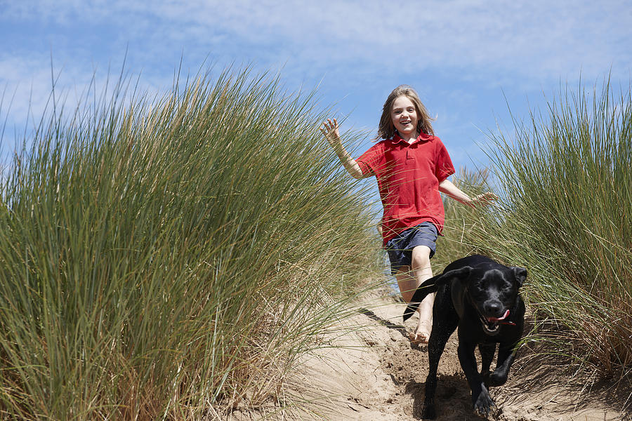 Young Girl Chasing dog in sand dunes Photograph by Adie Bush