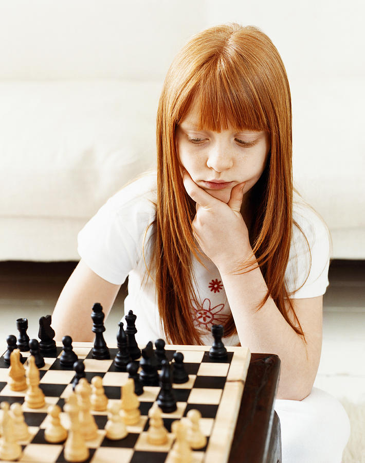 Young Girl Concentrating on a Chess Board Photograph by Lottie Davies