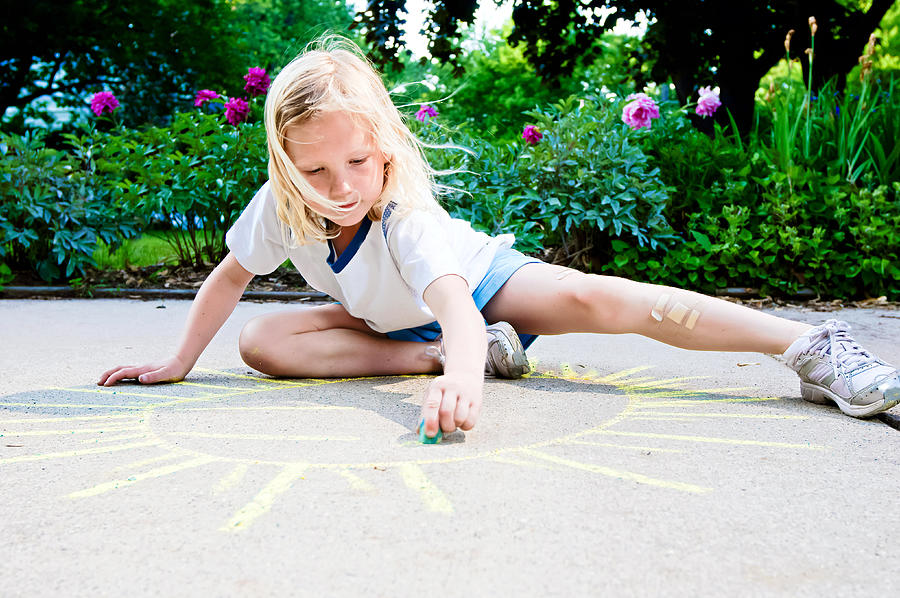 Young girl drawing sunshine with sidewalk chalk Photograph by Randy Riksen Photography