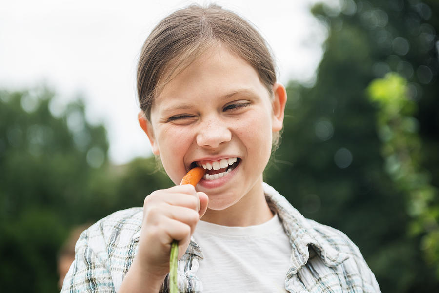 Young Girl Eating Fresh Carrot Photograph by Hinterhaus Productions