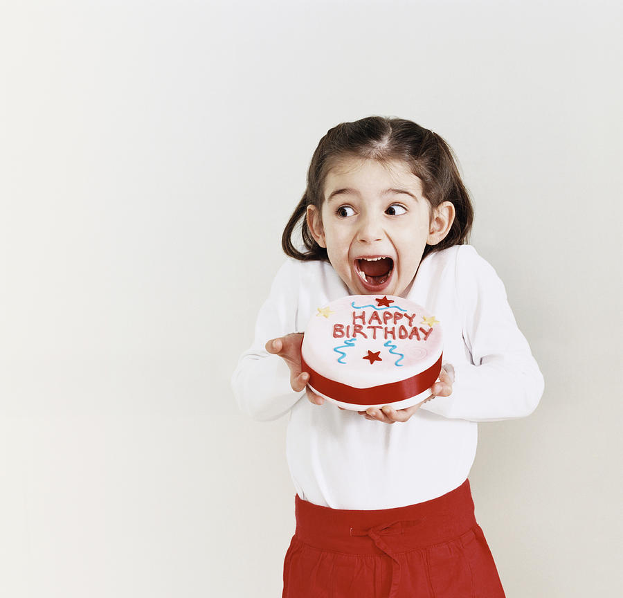 Young Girl Greedily Eating a Birthday Cake Photograph by Lottie Davies