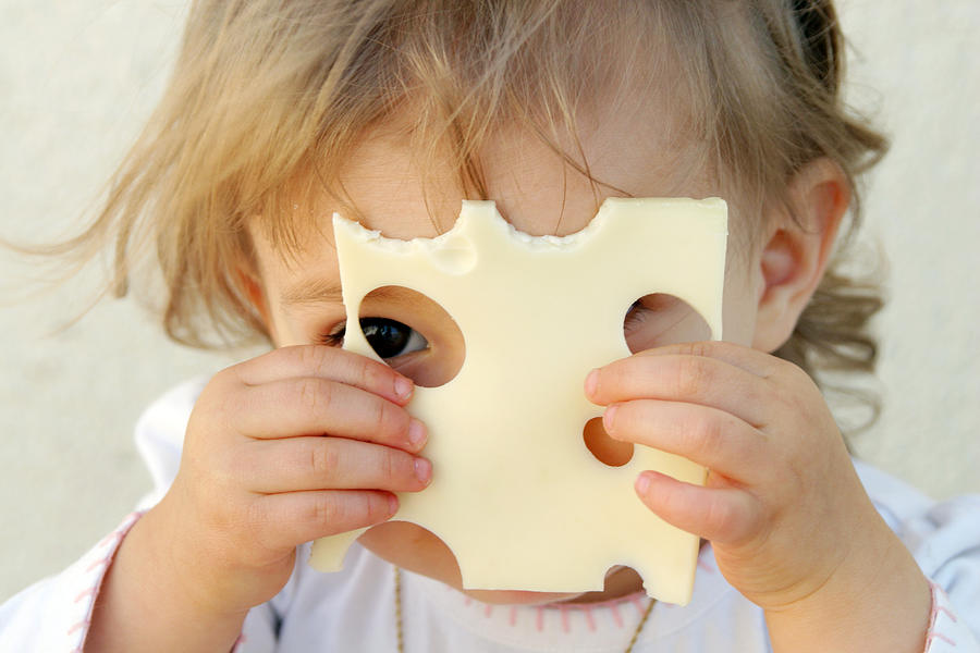 Young girl holding a slice of cheese over her face Photograph by Geri Lavrov