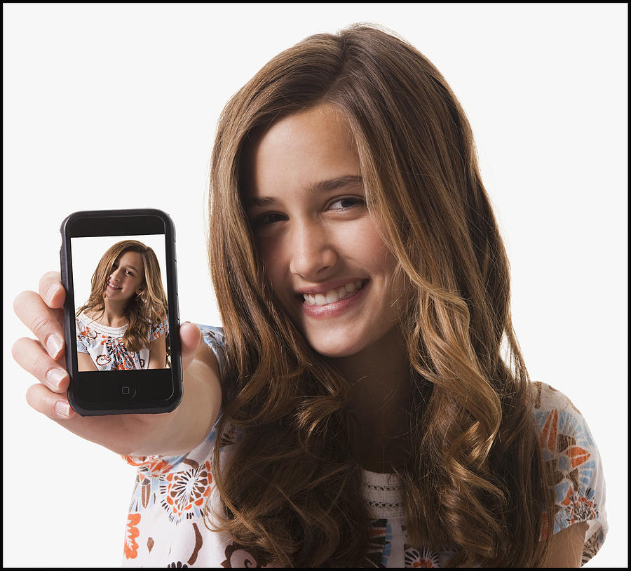 Young girl holding cellular phone Photograph by Mike Kemp