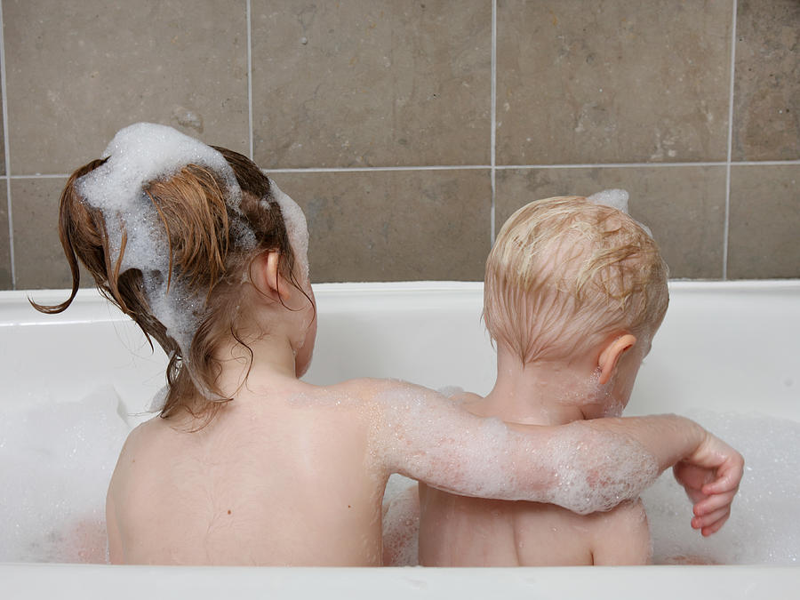 Young girl in tub with baby boy. Photograph by Katrina Wittkamp